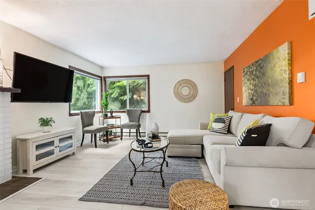 a living room with furniture a rug and a flat screen tv