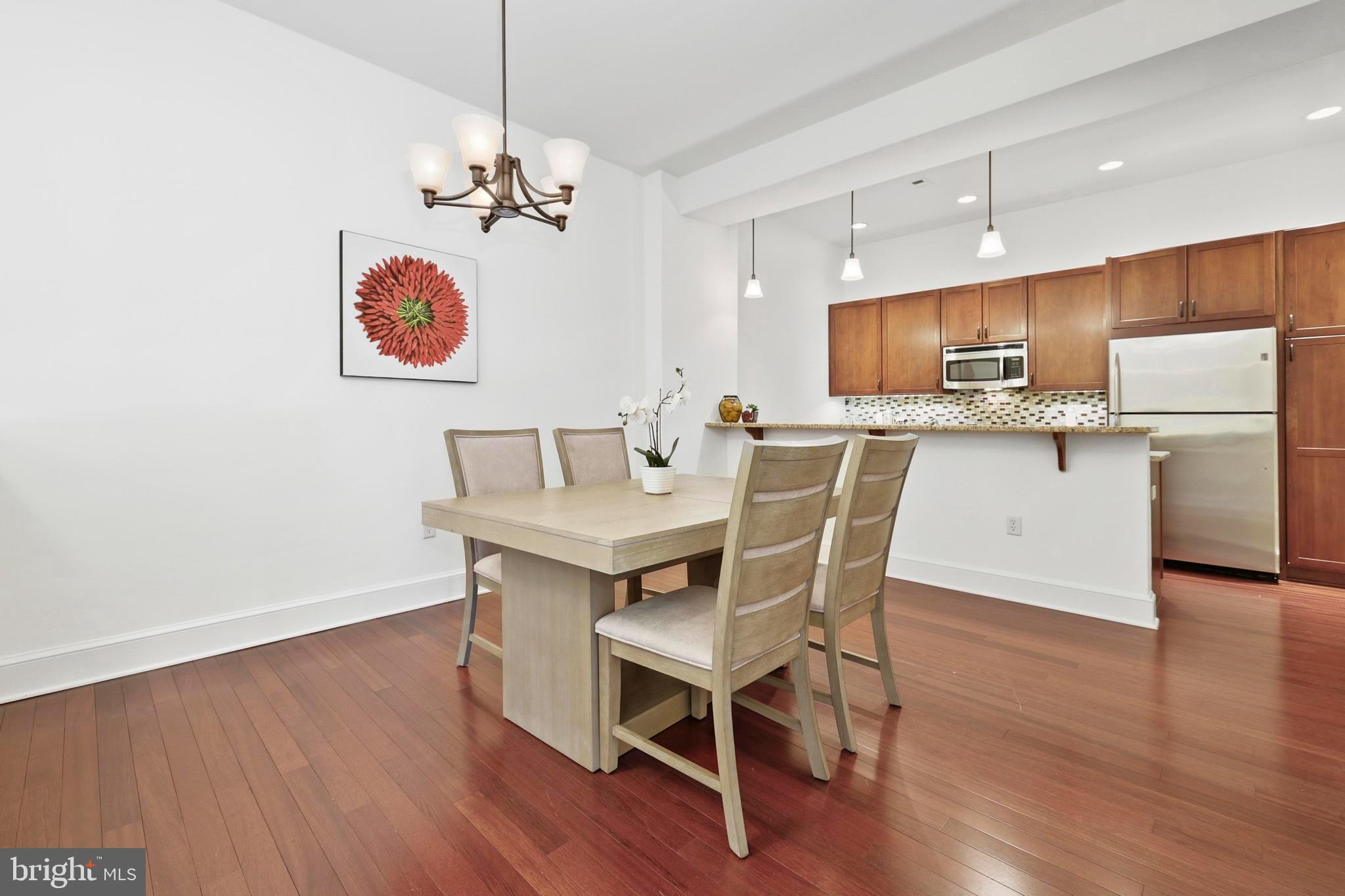 9610 Dewitt Drive, Unit BB03 Silver Spring, MD 20910 - Photo 6 of 28 a kitchen with a dining table chairs refrigerator and microwave