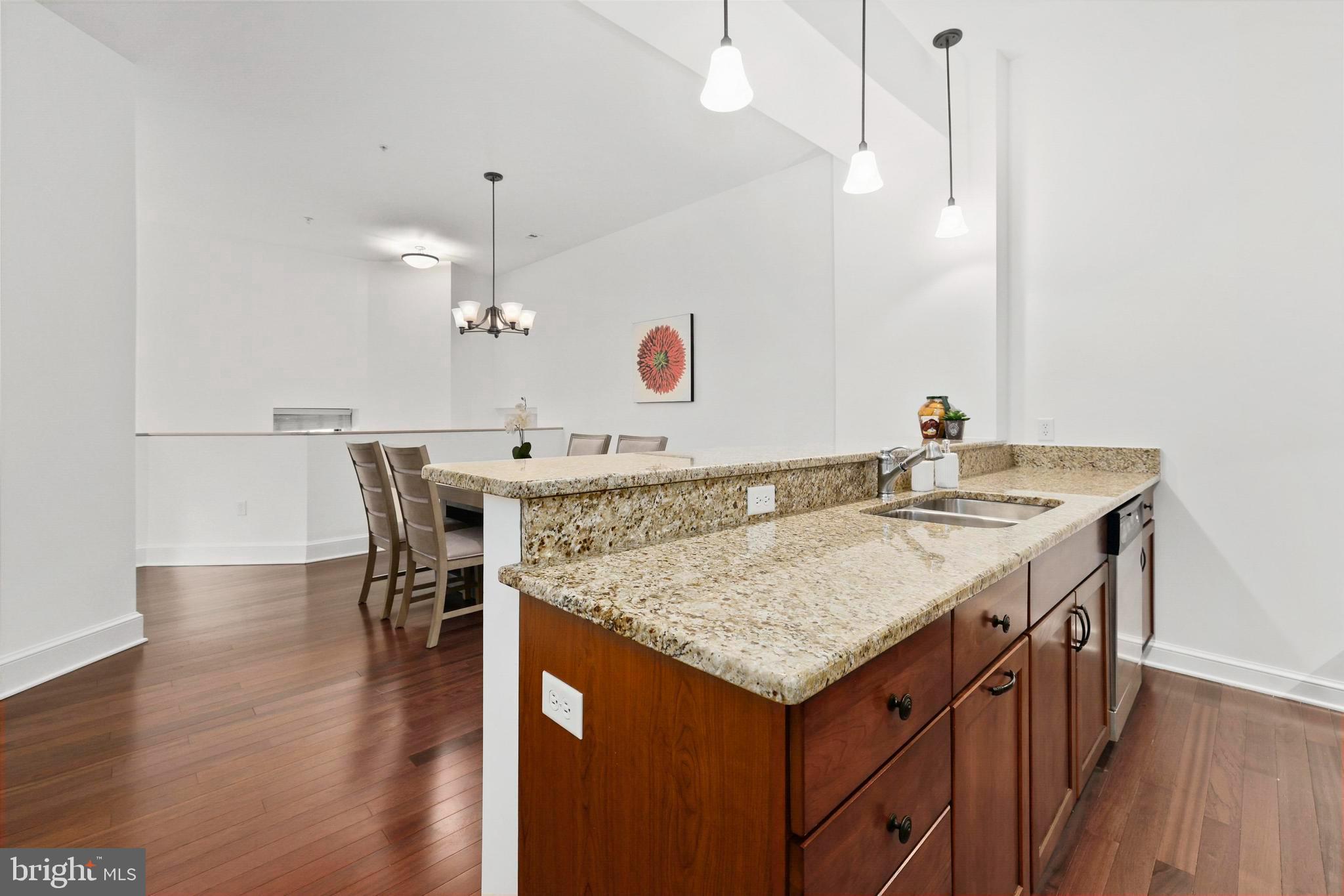 9610 Dewitt Drive, Unit BB03 Silver Spring, MD 20910 - Photo 10 of 28 a view of kitchen island with granite countertop stove sink and wooden floor