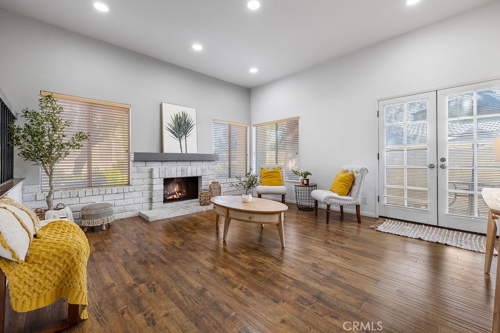 a living room with furniture a fireplace and wooden floor