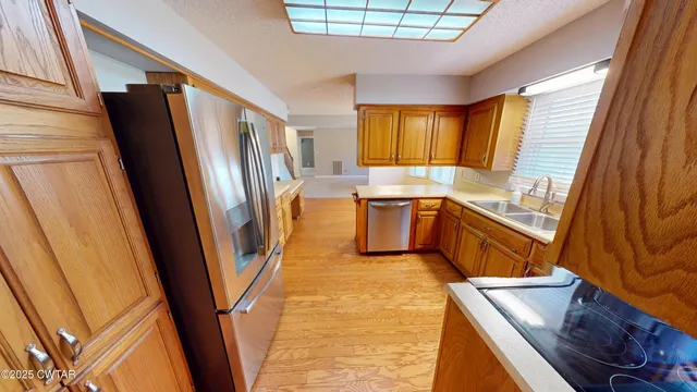 a kitchen with stainless steel appliances granite countertop a refrigerator and a sink