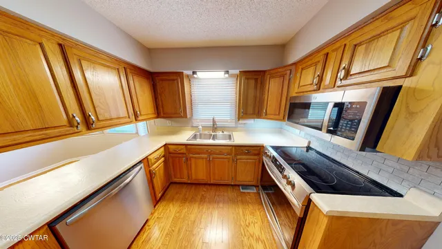 a kitchen with stainless steel appliances granite countertop sink stove and cabinets