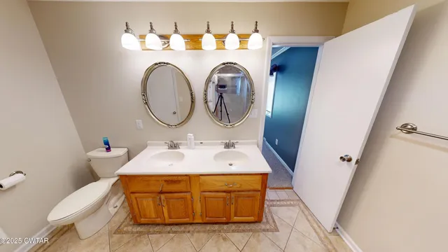 a bathroom with a sink mirror and toilet