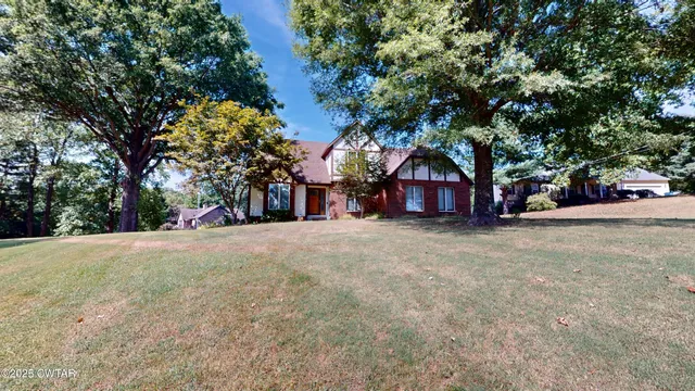 a view of a house with a yard and tree s