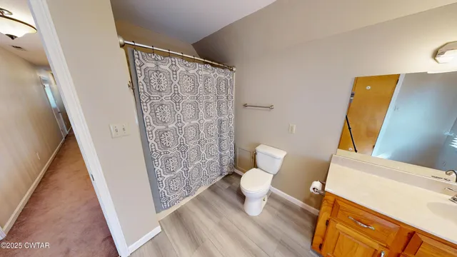 a bathroom with a toilet and a shower curtain