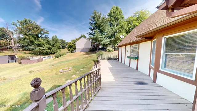 a view of a balcony with wooden floor and floor to ceiling window