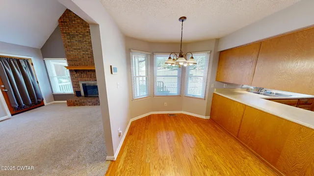a view of a kitchen with a sink and dishwasher with wooden floor