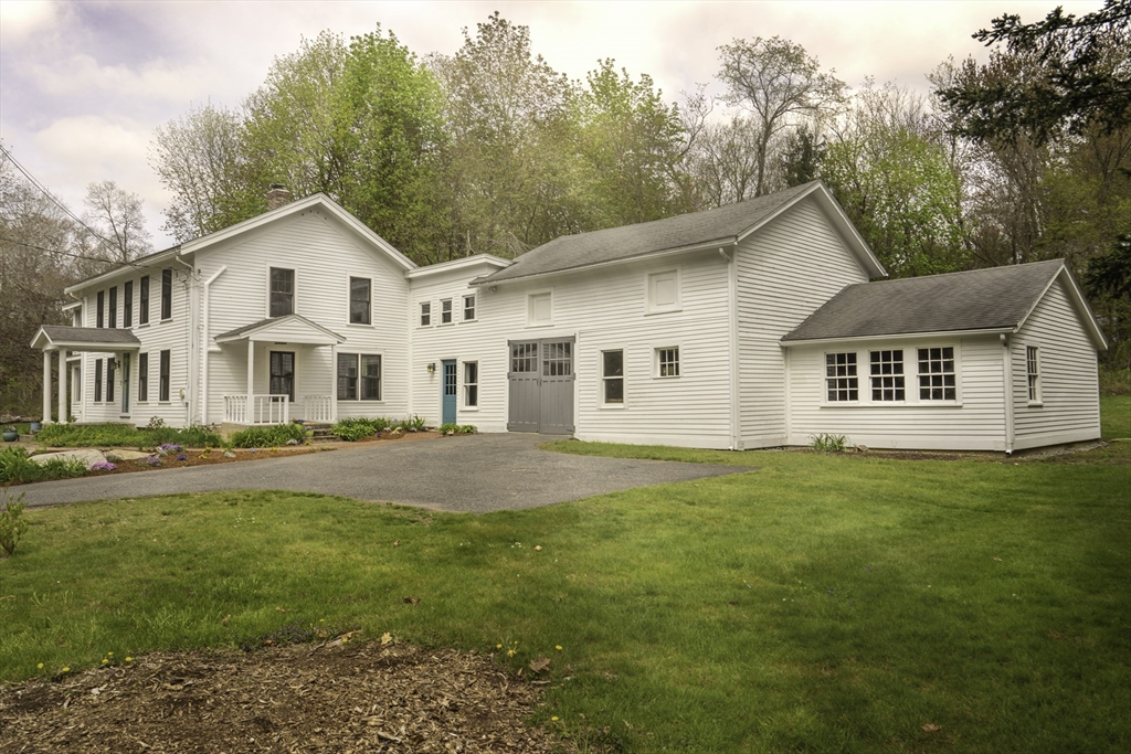 a front view of a house with a garden and yard