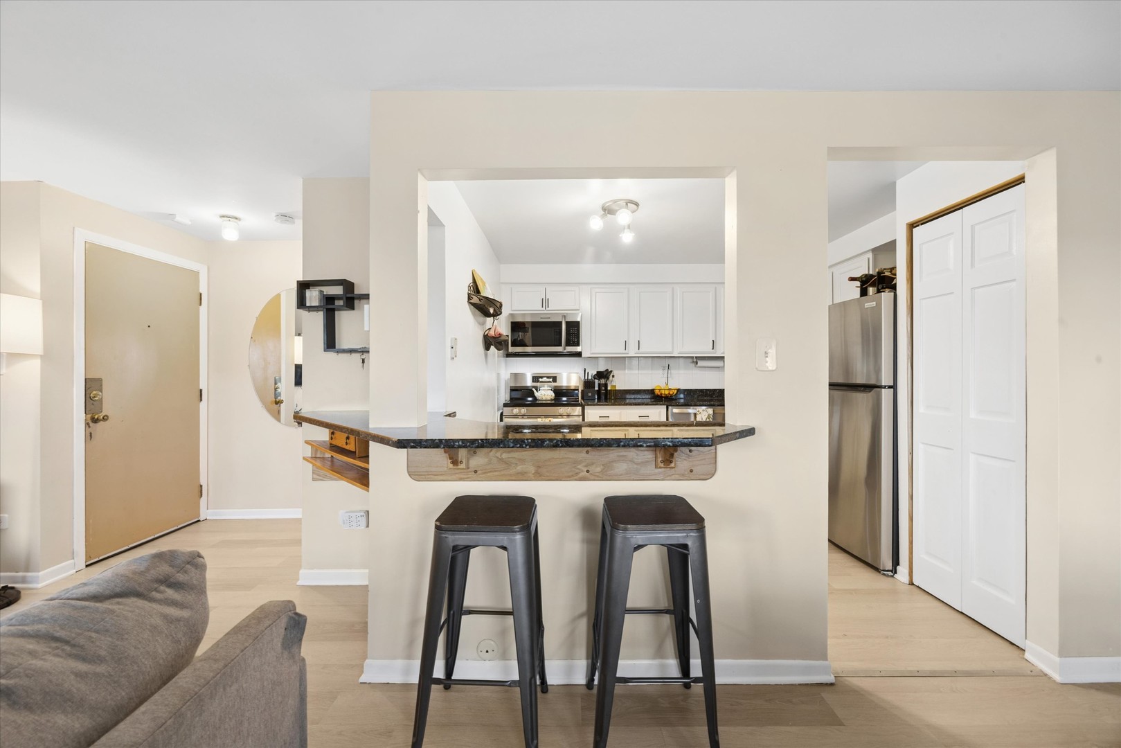1240 South Lorraine Road, Unit 3B Wheaton, IL 60189 - Photo 5 of 17 a kitchen with stainless steel appliances granite countertop a dining table chairs refrigerator and sink