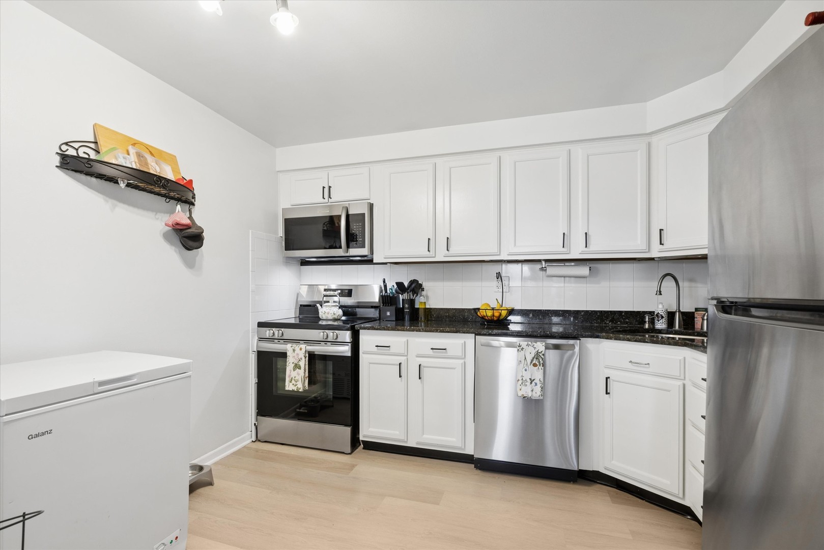 1240 South Lorraine Road, Unit 3B Wheaton, IL 60189 - Photo 6 of 17 a kitchen with granite countertop white cabinets and white appliances