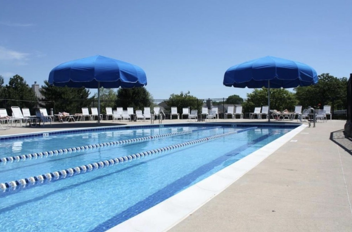 12963 Penefield Lane Huntley, IL 60142 - Photo 21 of 33 a view of a swimming pool with a table and chairs under an umbrella