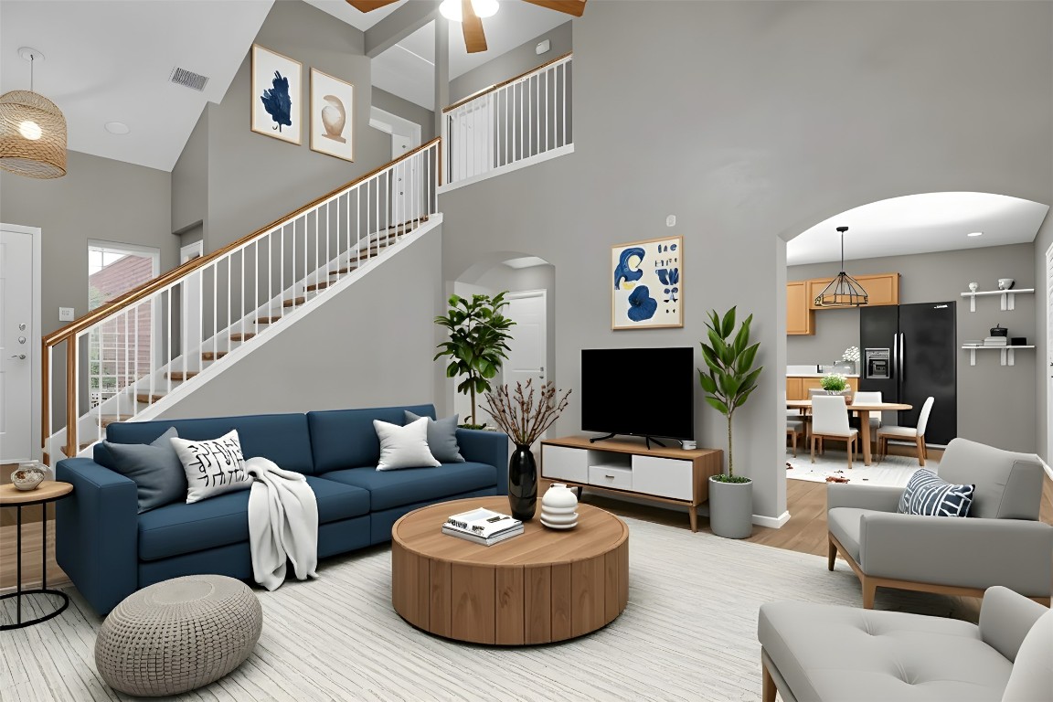 3007 Rainy River Drive Leander, TX 78641 - Photo 2 of 34 Virtually staged - Living area featuring light wood-style flooring, a towering ceiling, arched walkways, stairway, and a ceiling fan