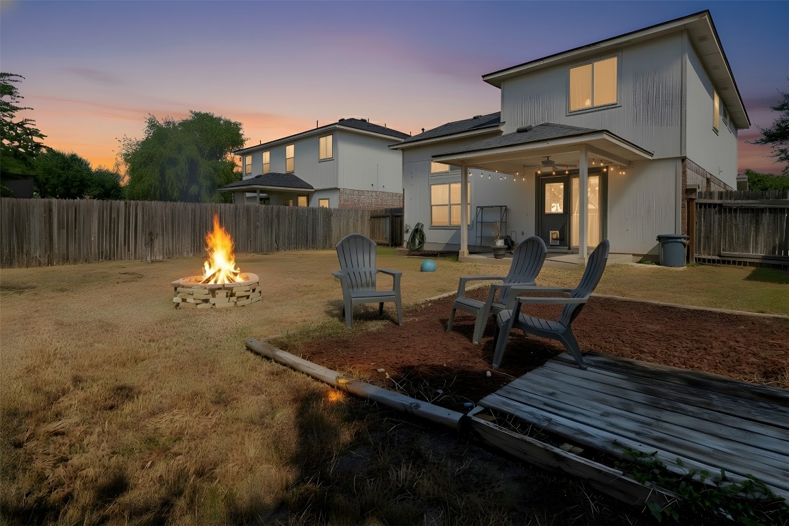 3007 Rainy River Drive Leander, TX 78641 - Photo 21 of 34 Virtually staged - Back of home at dusk featuring a patio area, a fire pit, and fenced backyard