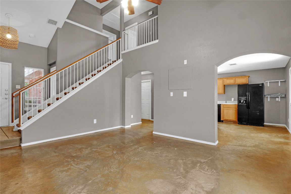 3007 Rainy River Drive Leander, TX 78641 - Photo 3 of 34 Living area featuring light wood-style flooring, a towering ceiling, arched walkways, stairway, and a ceiling fan