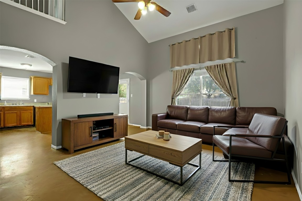 3007 Rainy River Drive Leander, TX 78641 - Photo 4 of 34 Virtually staged - Living area featuring arched walkways, a ceiling fan, high vaulted ceiling, and concrete flooring