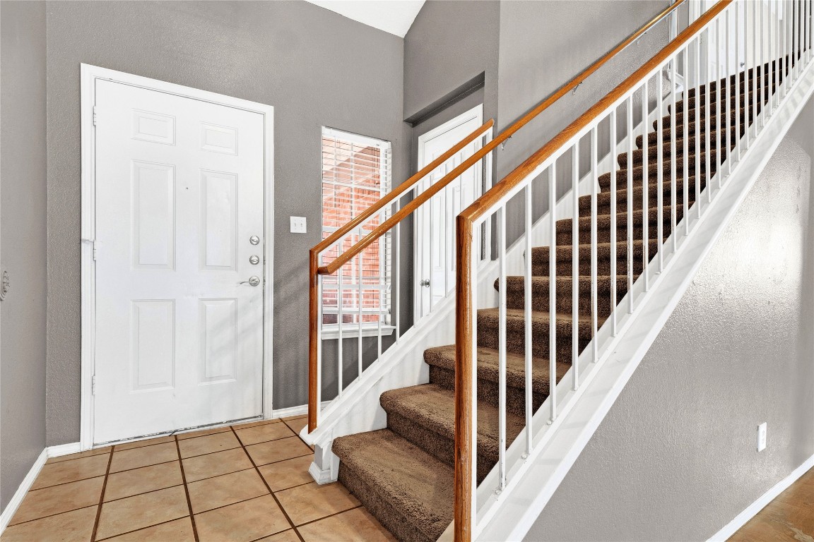 3007 Rainy River Drive Leander, TX 78641 - Photo 6 of 34 Entryway with a textured wall, tile patterned flooring, and stairway