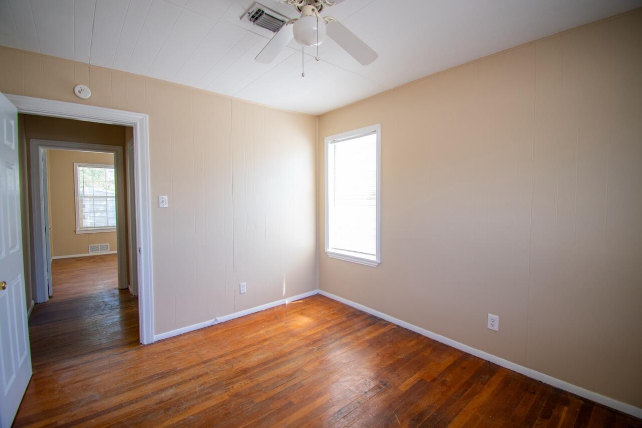 2424 27th Street Lubbock, TX 79411 - Photo 9 of 14 a view of empty room with wooden floor and fan