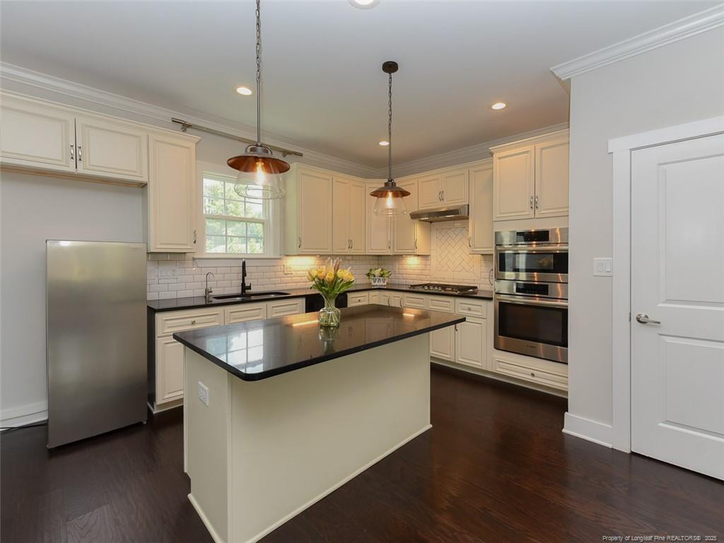 723 Lindley Drive Durham, NC 27703 - Photo 11 of 37 a kitchen with stainless steel appliances granite countertop a sink a stove and a refrigerator