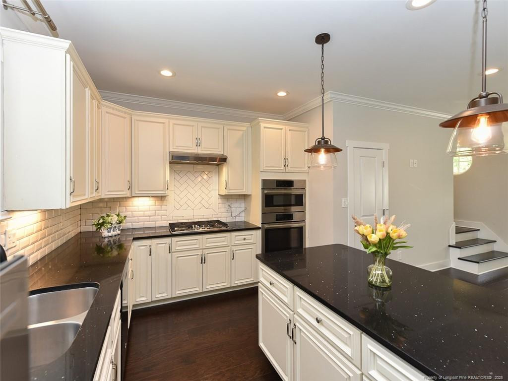 723 Lindley Drive Durham, NC 27703 - Photo 12 of 37 a kitchen with stainless steel appliances granite countertop a sink a stove and cabinets