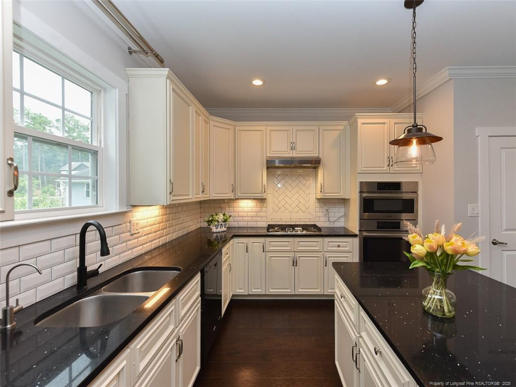 723 Lindley Drive Durham, NC 27703 - Photo 13 of 37 a kitchen with stainless steel appliances granite countertop sink stove and cabinets