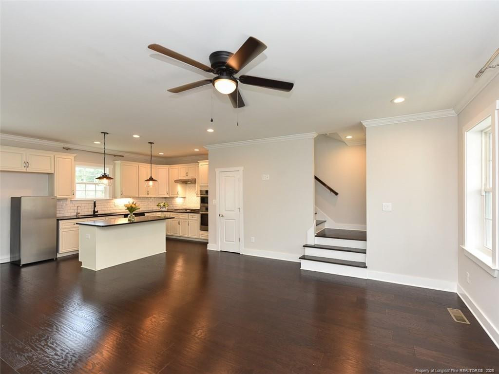 723 Lindley Drive Durham, NC 27703 - Photo 9 of 37 a kitchen with stainless steel appliances kitchen island granite countertop a refrigerator and a view of living room