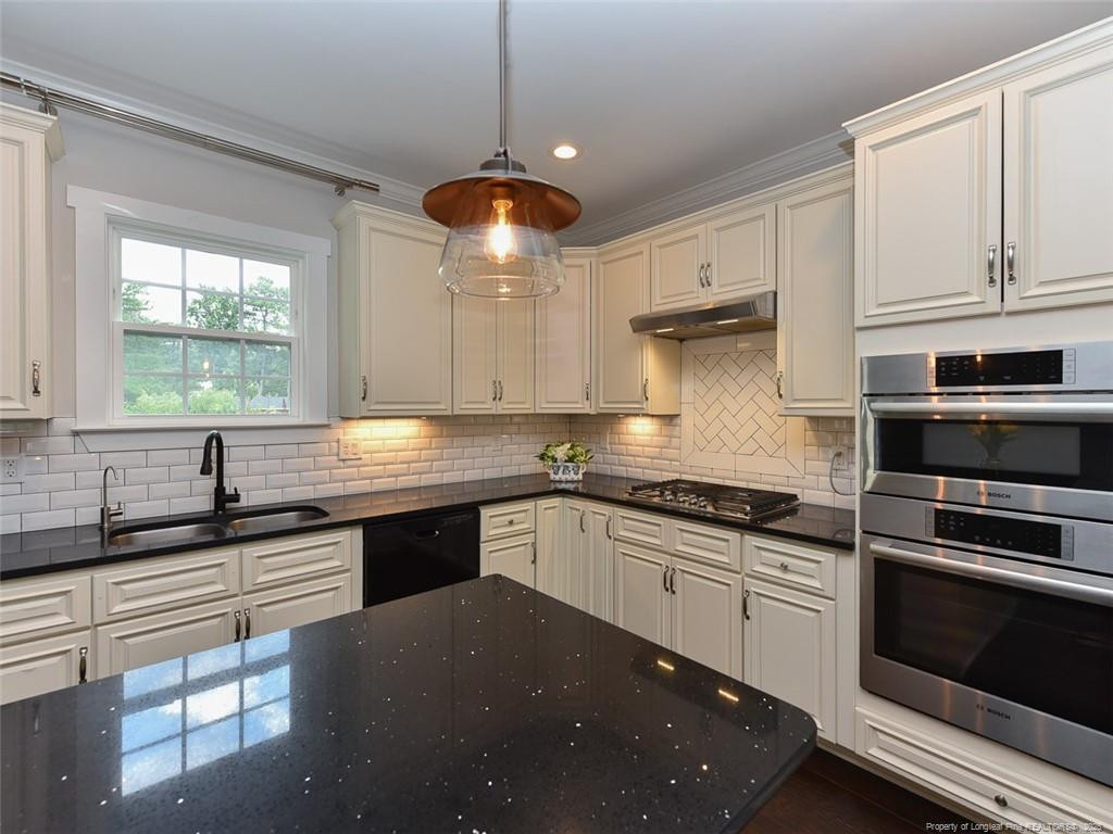 723 Lindley Drive Durham, NC 27703 - Photo 10 of 37 a kitchen with stainless steel appliances granite countertop a sink a stove a microwave and cabinets