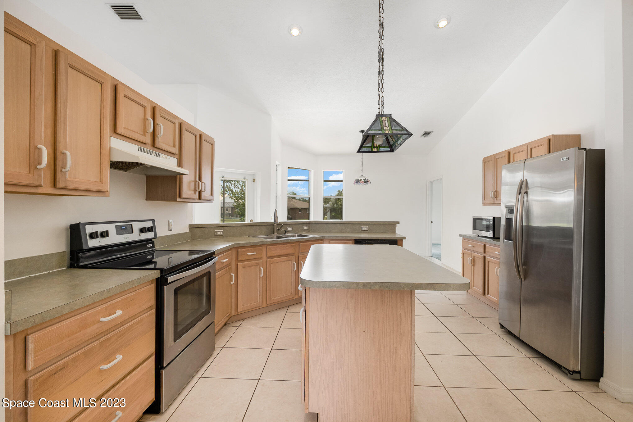 128 Palm Circle Melbourne, FL 32940 - Photo 13 of 30 a kitchen with stainless steel appliances granite countertop a sink a stove a refrigerator cabinets and a kitchen island