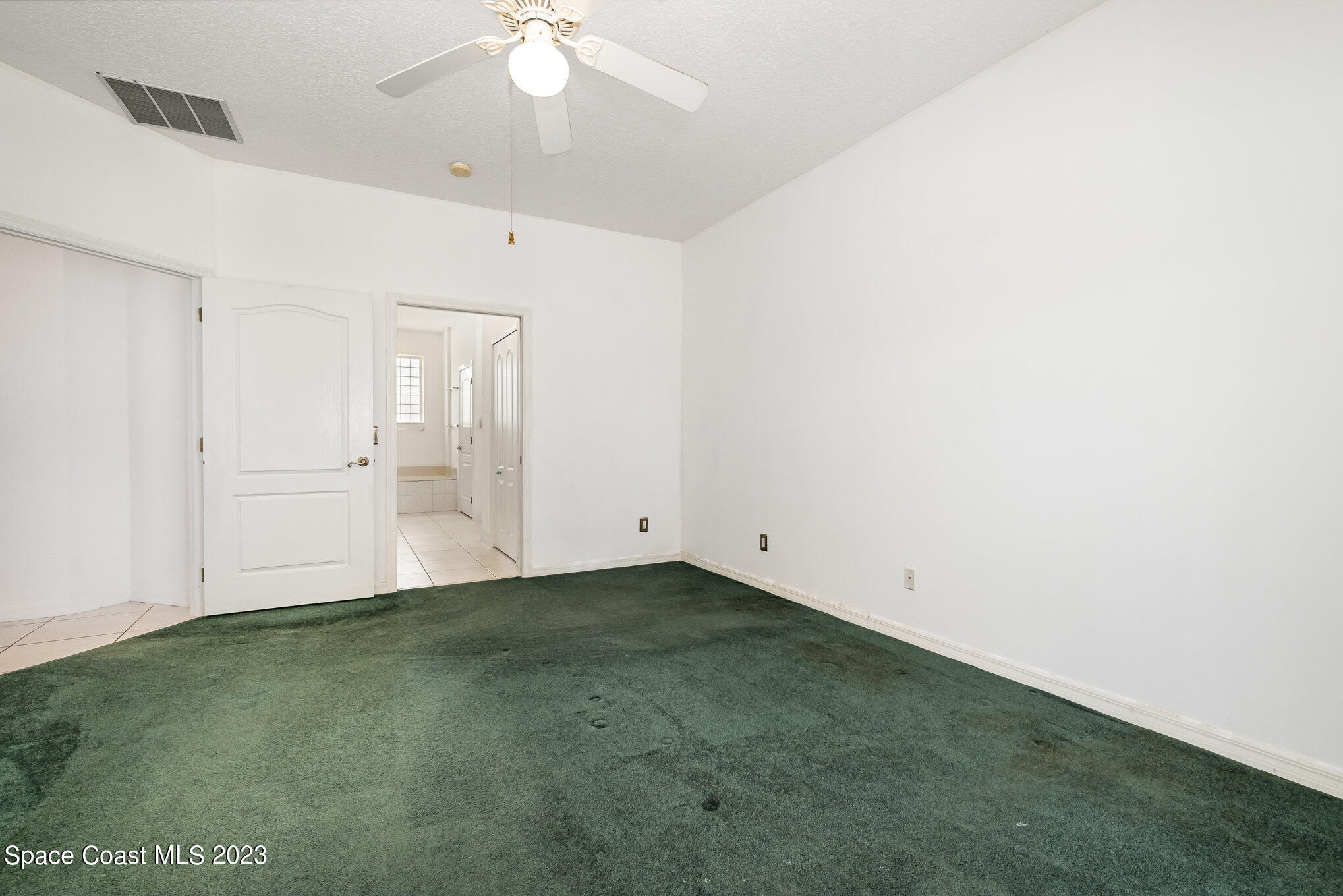 128 Palm Circle Melbourne, FL 32940 - Photo 20 of 30 an empty room with an entryway and chandelier fan