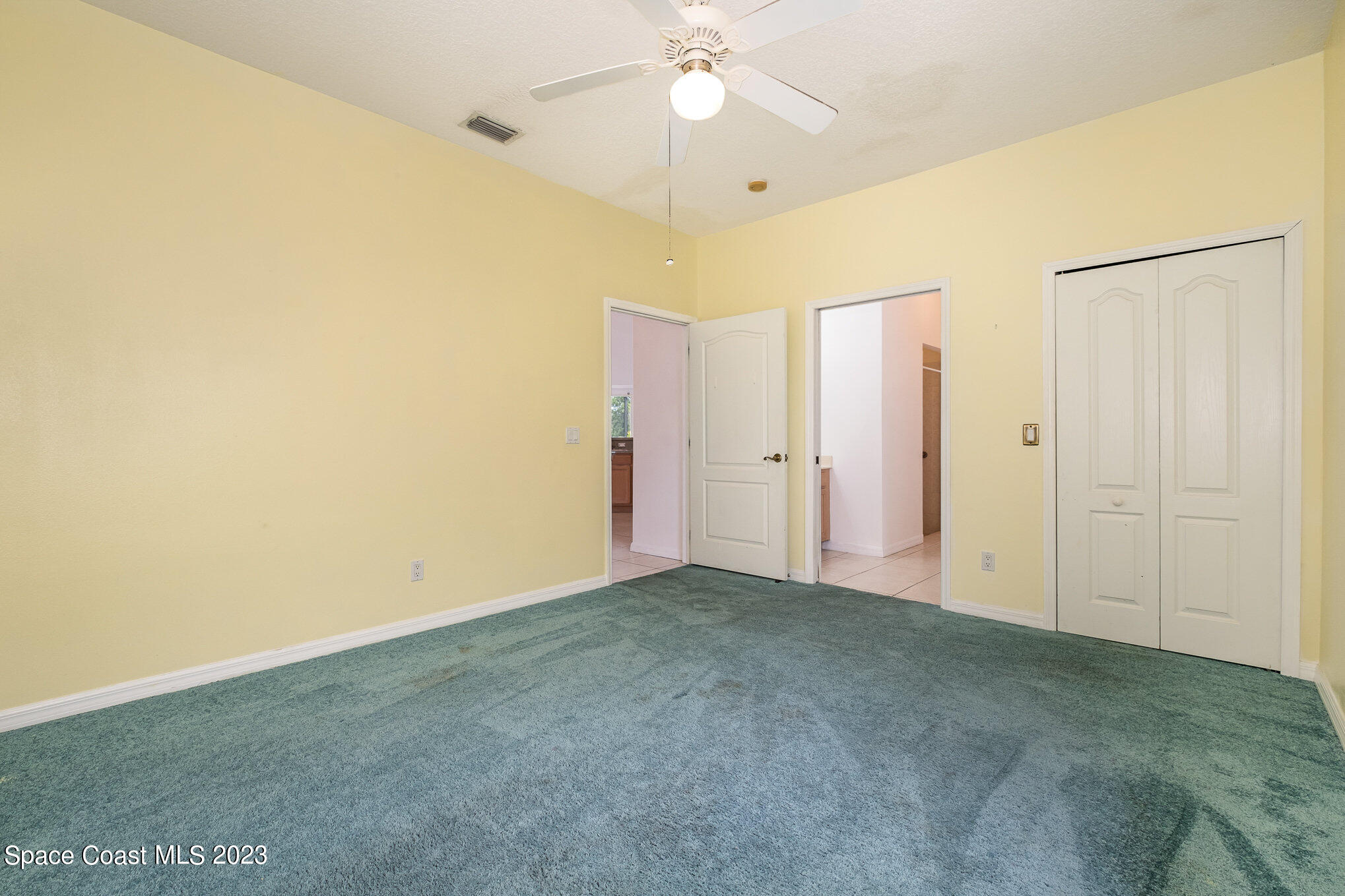 128 Palm Circle Melbourne, FL 32940 - Photo 23 of 30 an empty room with a ceiling fan and carpet