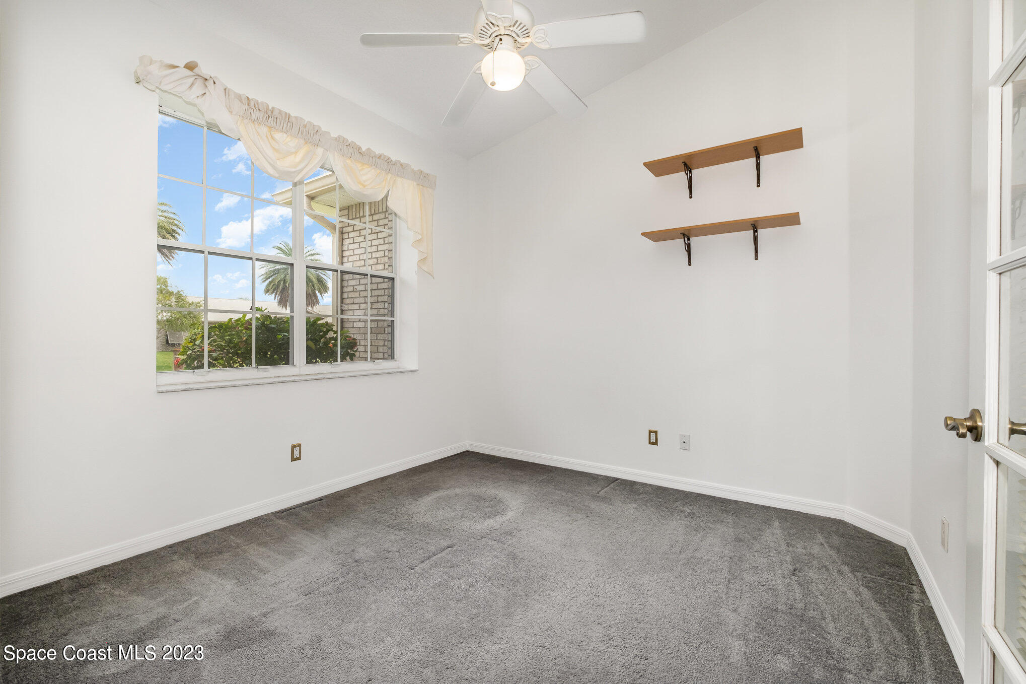 128 Palm Circle Melbourne, FL 32940 - Photo 24 of 30 an empty room with windows and fan