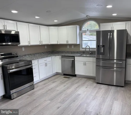 a kitchen with stainless steel appliances granite countertop a stove a refrigerator and a microwave