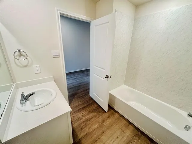 a bathroom with a sink a bathtub and vanity