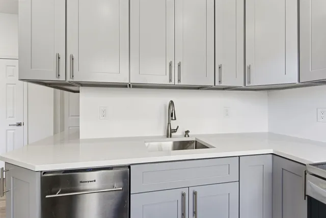 a kitchen with stainless steel appliances granite countertop white cabinets and a sink