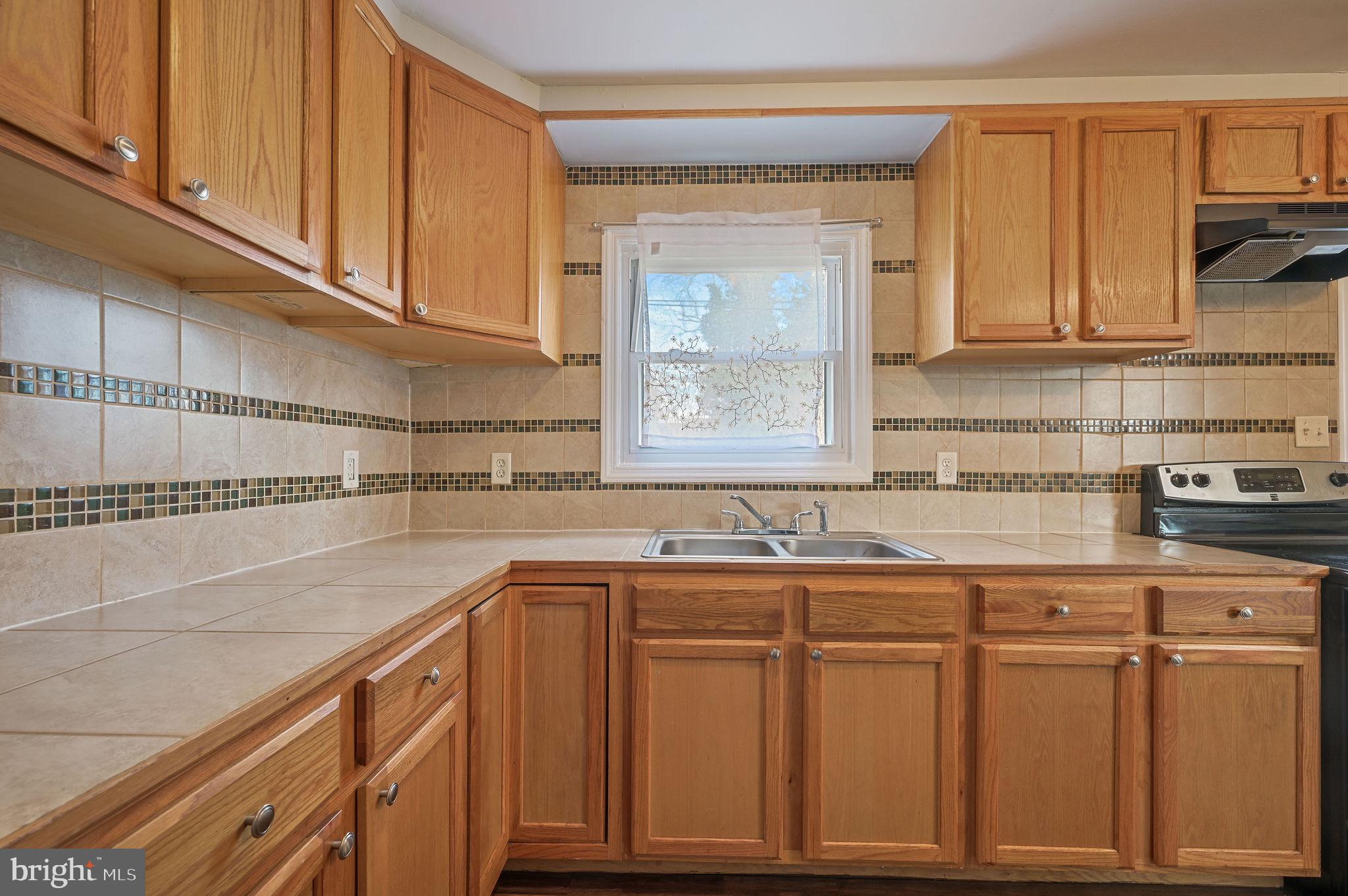 1431 Joshua Clayton Road Dover, DE 19904 - Photo 10 of 31 a kitchen with stainless steel appliances granite countertop a sink and cabinets with wooden floor