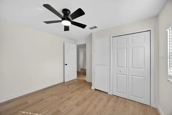 an empty room to hallway with wooden floor