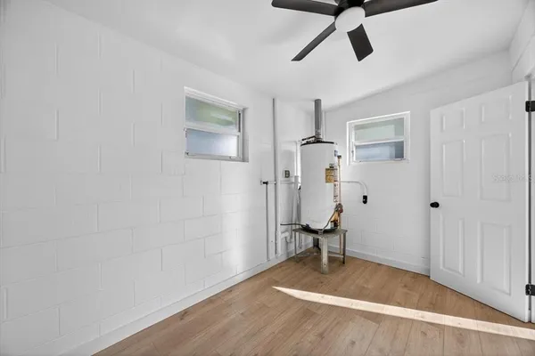 a view of empty room with wooden floor and ceiling fan