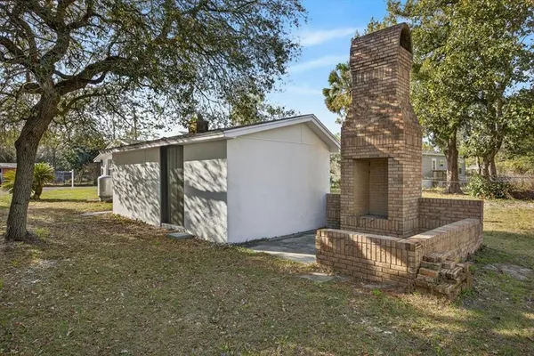 a view of a house with a large tree and wooden fence