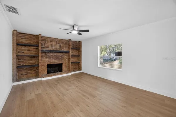 a view of an empty room with a fireplace and a window