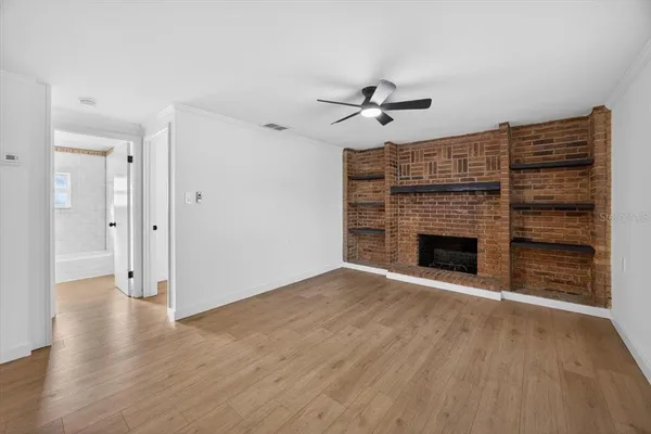 a view of empty room with wooden floor and fireplace