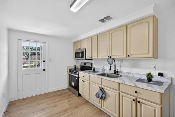 a kitchen with stainless steel appliances granite countertop white cabinets stove a sink and dishwasher