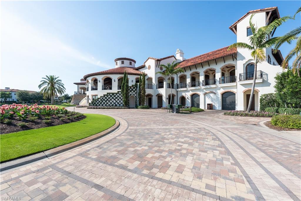 16336 Corsica Way, Unit 201 Naples, FL 34110 - Photo 34 of 34 View of front facade featuring stucco siding, a tile roof, curved driveway, and a chimney