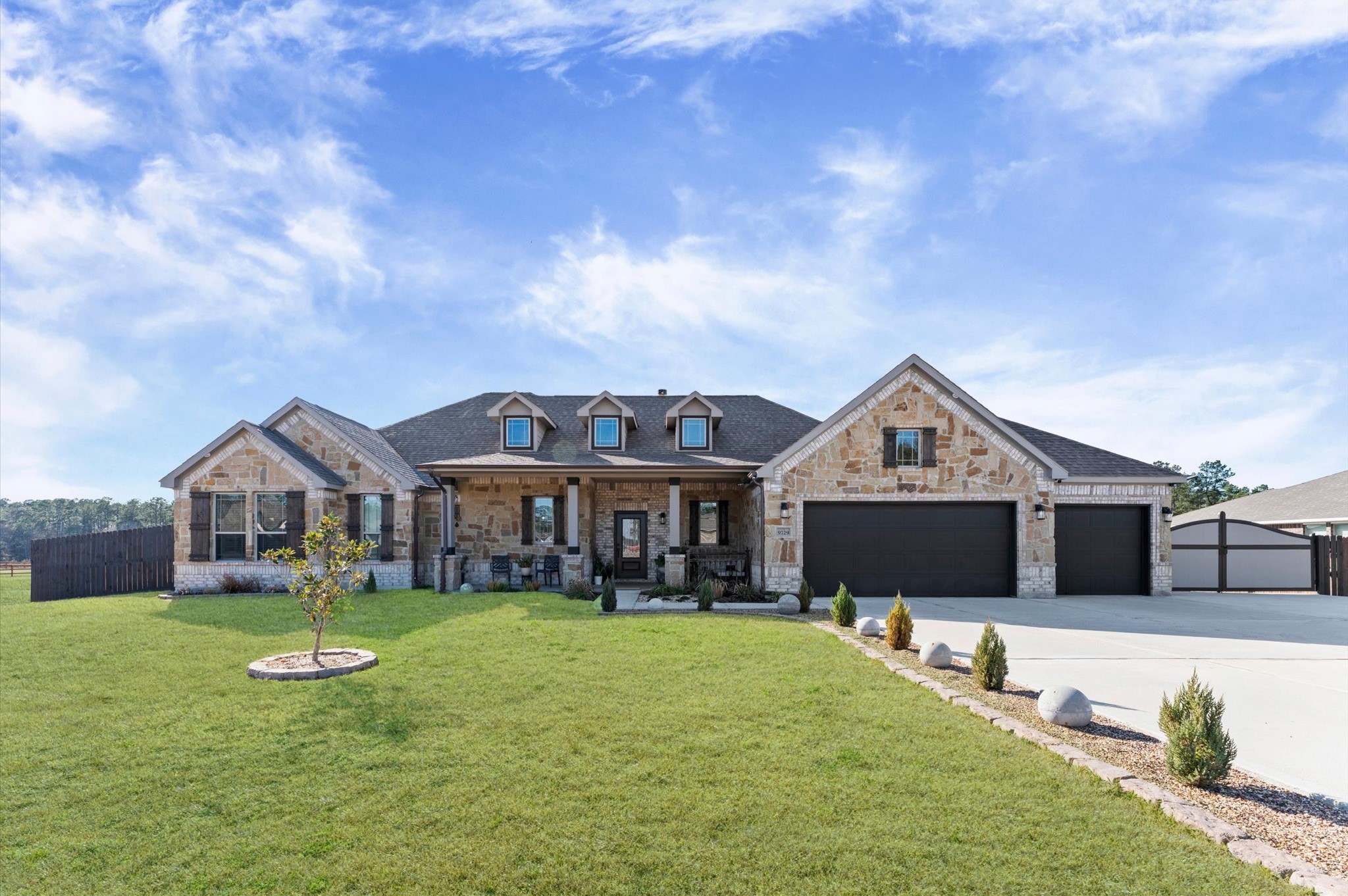 9729 Hidalgo Street Conroe, TX 77303 - Photo 1 of 38 Spacious, single-story stone and brick home with a three-car garage and newly tiled front porch offer a blend of elegance and comfort.