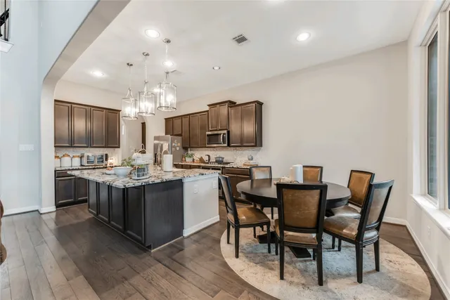 a kitchen with kitchen island granite countertop wooden cabinets and stainless steel appliances