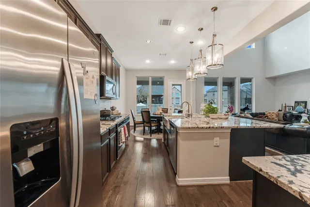 a kitchen with stainless steel appliances granite countertop a sink stove and refrigerator