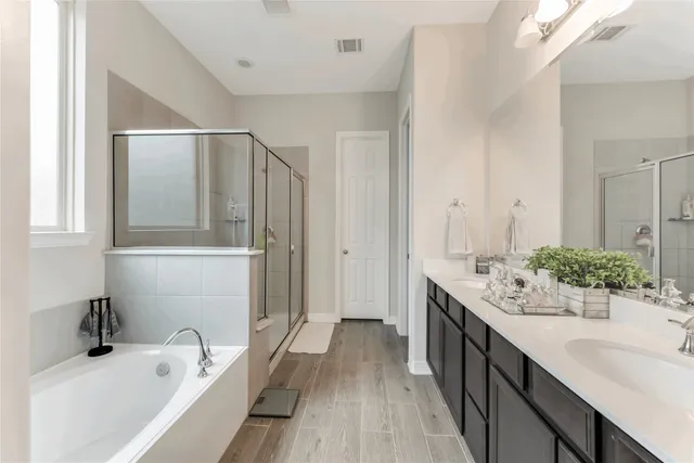 a bathroom with a tub sink and mirror
