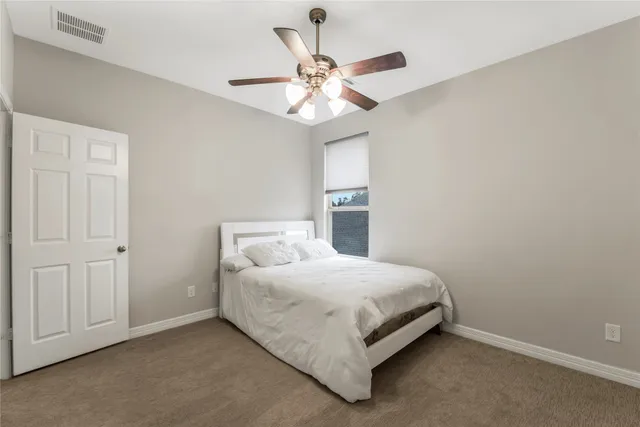 a bedroom with a bed and a ceiling fan
