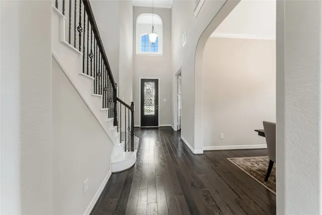 a view of a hallway with wooden floor and staircase