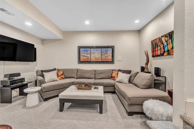 a living room with furniture a flat screen tv and kitchen view