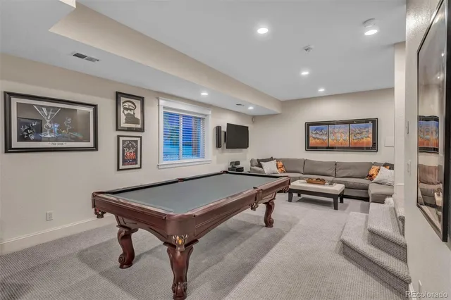 a living room with furniture pool table and a lamp