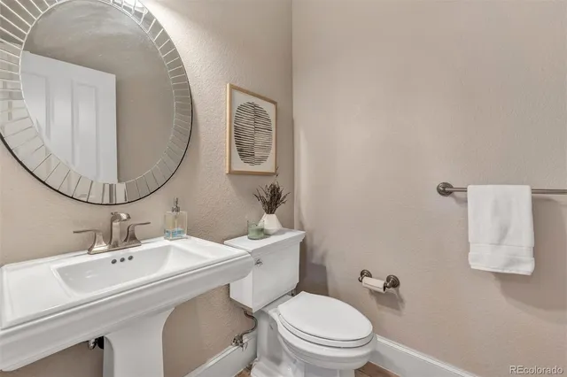a bathroom with a toilet a sink and mirror